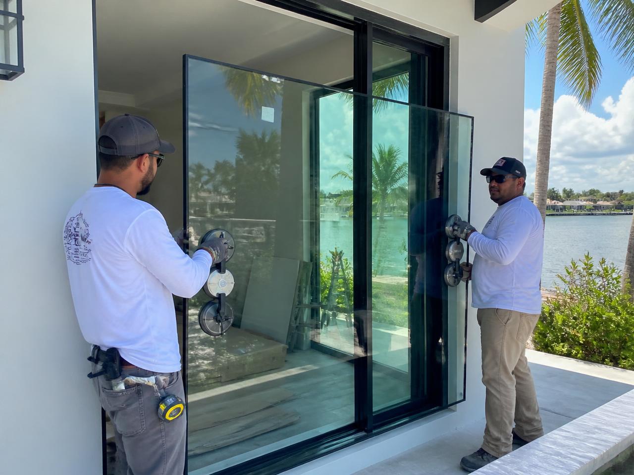 Technicians setting a new impact-rated glass pane with suction cups
