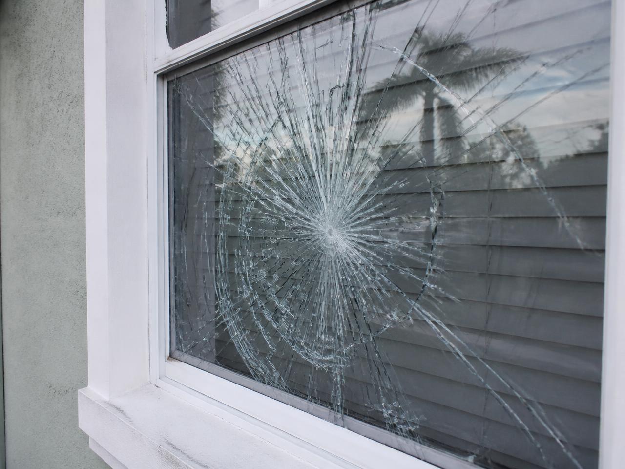 Cracked residential window pane in a white frame
